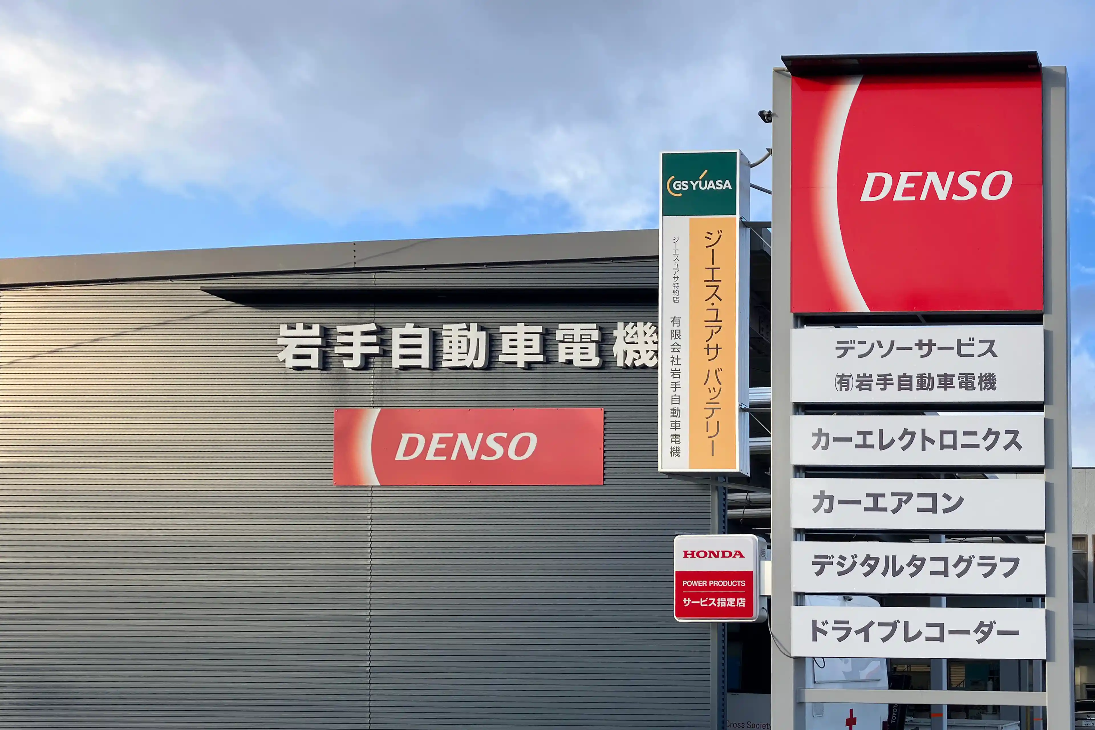 有限会社岩手自動車電機の社屋外観と、「DENSO」のロゴが掲げられた看板