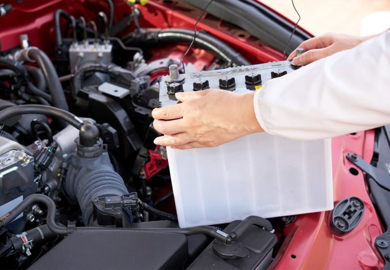 車のバッテリーを交換している整備士の手元